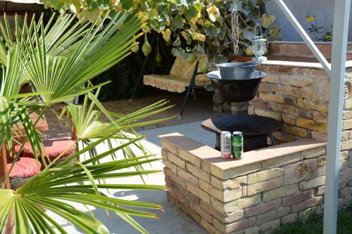 a patio with a brick fire pit and plants at Unicum Vendégház in Abádszalók