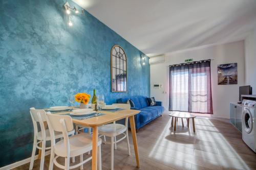 a living room with a table and a blue wall at Tritoni Harbour suites - Valletta in Valletta