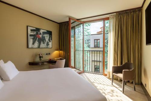 a hotel room with a large bed and a large window at NH Collection Carlo IV in Prague