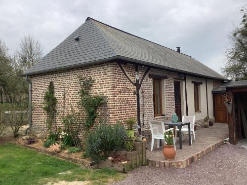 a small brick house with a table and chairs at Gîte à la campagne in Saint-Léger-du-Gennetey