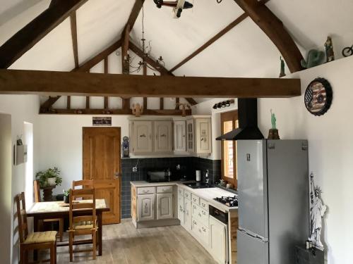  La cuisine est équipée de placards blancs et d'un réfrigérateur. dans l'établissement Gîte à la campagne, à Saint-Léger-du-Gennetey