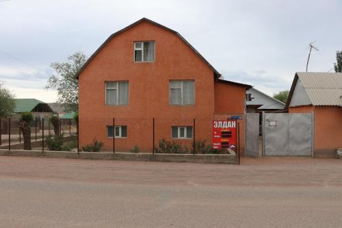 a large red brick building with a red gas pump at Guest House Baiel in Bokonbayevo
