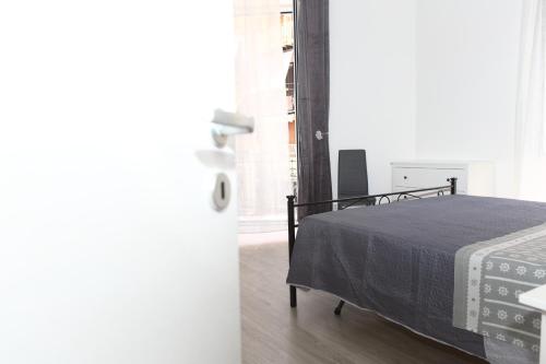 a bedroom with a bed with a gray blanket at Suite Garibaldi in Cefalù