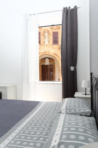 a bedroom with a bed and a view of a building at Suite Garibaldi in Cefalù