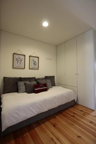 a bedroom with a large bed with white cabinets at OPORTO GUEST Natária Flats with Parking in Porto