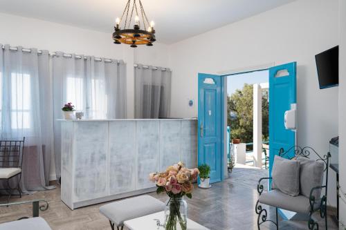 una sala de estar con una puerta azul y un jarrón de flores en Porto Villa, en Vlychada