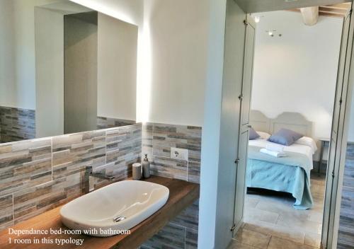 a bathroom with a tub and a bedroom with a bed at Borgo Solario in Castiglione del Lago