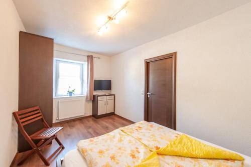 a bedroom with a bed and a chair and a window at Appartement 101 in Bichlbach