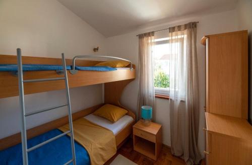 a small room with two bunk beds and a window at Sisi Apartment in Vabriga