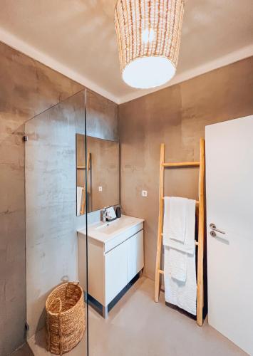 ein Badezimmer mit Waschbecken und Dusche in der Unterkunft Maison Comporta in Comporta