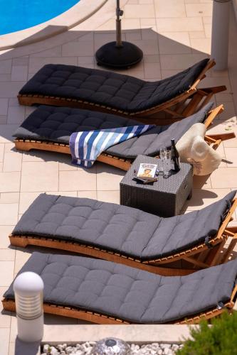 a group of three blue pillows on a patio at Hektorovic poolside apartments in Bol