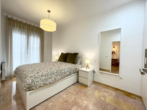 1 dormitorio con cama y espejo grande en Magnífico apartamento con excelente ubicación en Don Benito