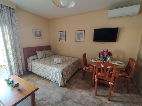 um quarto com uma mesa e uma cama e uma mesa e cadeiras em VIVE BENALMADENA ESTUDIO BENAL BEACH 4-314 em Benalmádena