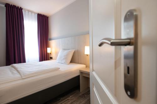 ein Hotelzimmer mit einem Bett und einem Fenster in der Unterkunft Nautic Hotel Bremerhaven in Bremerhaven