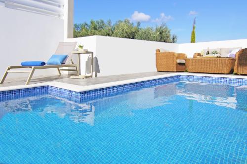 a swimming pool with a chair and a table and a chair at Villa Caren in Paralimni