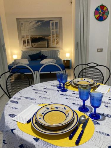 a dining room table with plates and utensils on it at Casa Vacanze Casti - 41 in Calasetta