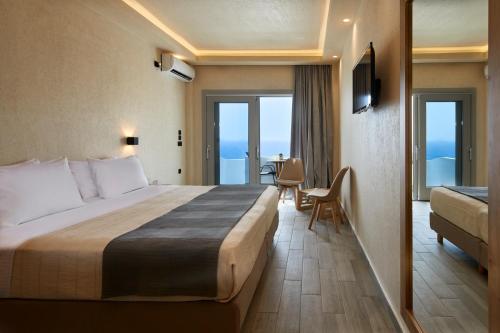 um quarto de hotel com uma cama grande e uma mesa em Acropole Sunrise em Kamari