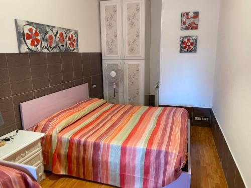 ein Schlafzimmer mit einem Bett mit einer bunten gestreiften Decke in der Unterkunft Giorno&Notte Colleferro in Colleferro