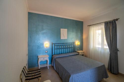 sypialnia z łóżkiem i niebieską ścianą w obiekcie Hotel Boutique Il Castellino Relais w mieście Vieste