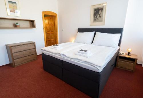 a bedroom with a large bed with white sheets at Hotel Uno in Ústí nad Orlicí