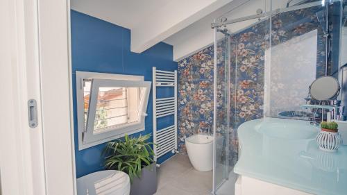 a blue bathroom with a sink and a mirror at Elide Home Sweet Home - Italian Homing in Padenghe sul Garda