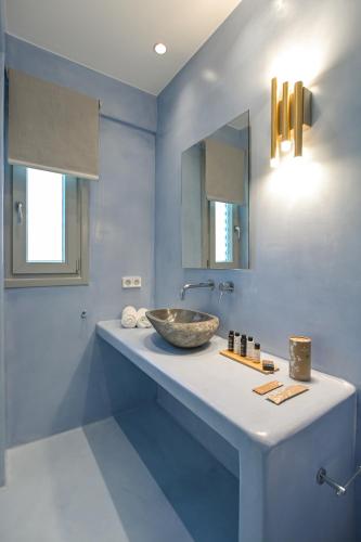 a bathroom with a bowl sink and blue walls at Villa Armelina in Plaka