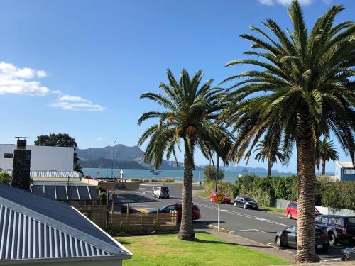 two palm trees in front of a parking lot at The Publican's Palace in Whitianga