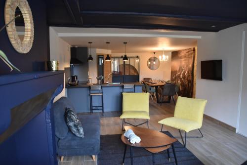 a living room with a couch and chairs and a kitchen at Le refuge de la Sallée in Gençay