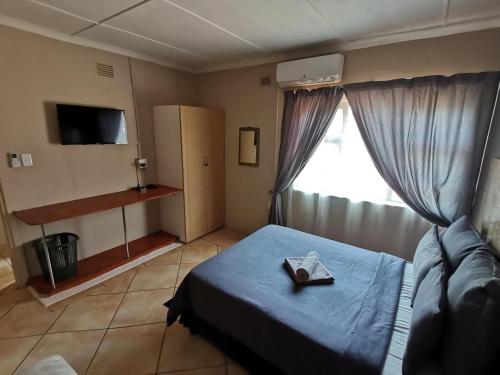 - une chambre avec un lit avec une croix dans l'établissement Hluzu Guest House, à Hluhluwe
