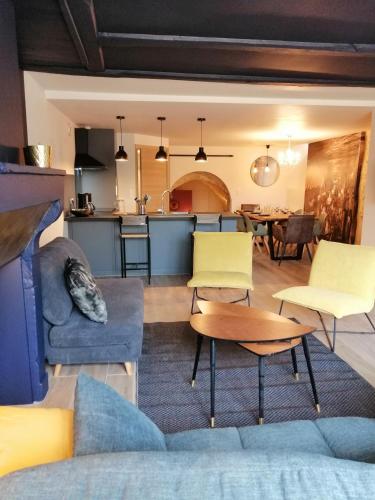 un salon avec un canapé et des chaises et une cuisine dans l'établissement Le refuge de la Sallée, à Gençay