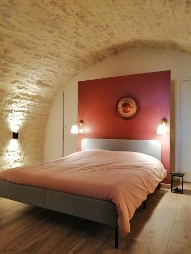 - une chambre dotée d'un lit avec un mur rouge dans l'établissement Le refuge de la Sallée, à Gençay