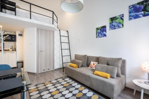 Una sala de estar con un sofá y una cama alta. en Cozy Home Studio, en Budapest