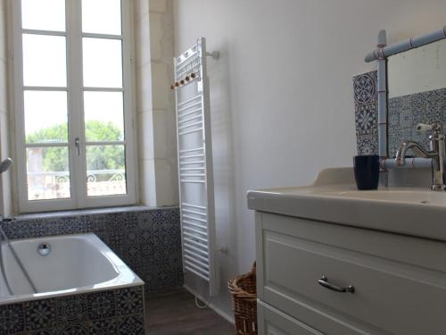 La salle de bains est pourvue d'un lavabo, d'une baignoire et d'une fenêtre. dans l'établissement Maison de Maître 1800 - 18 couchages - Jardin Clos - Saint-Georges-d'Oléron - FR-1-246A-61, à Saint-Georges-dʼOléron