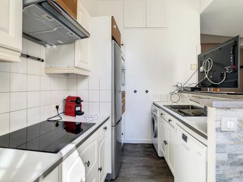 une cuisine avec des armoires blanches et un appareil rouge sur un comptoir dans l'établissement 2 Bedroom luxury flat Cannes Center La Croisette, à Cannes