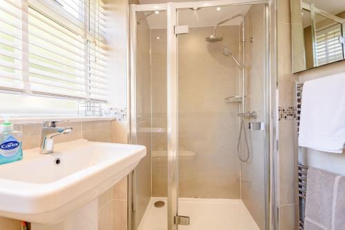 a bathroom with a sink and a shower at Kynaston Cottage in Aberdyfi