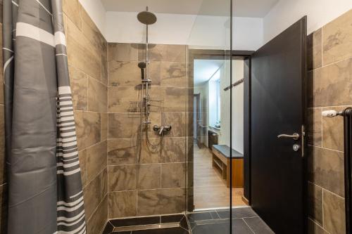 ein Bad mit einer Dusche und einer Glastür in der Unterkunft K2 Brunnen Haus in Kötschach