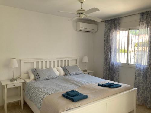 1 dormitorio con 1 cama con 2 toallas azules en Cozy Spanish house in Nueva Andalucia Golf Padel Hiking and Sun, en Marbella