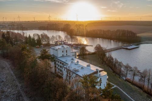 an aerial view of a building next to a river with wind turbines at Rezydencja Margonin in Margonin