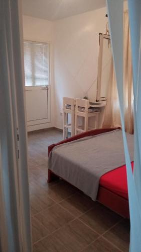 a bedroom with a bed and a table and chairs at Two in Petrovac na Moru