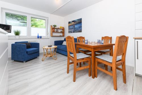 uma sala de estar com uma mesa e cadeiras e um sofá em Ferienwohnung Sonnenriff em Bensersiel