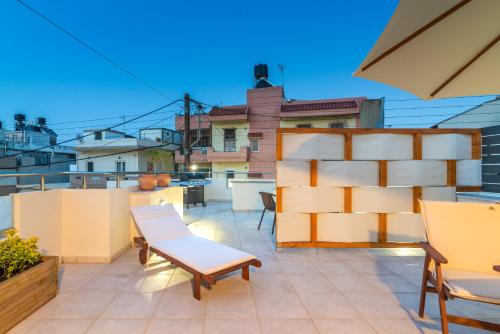 a balcony with chairs and tables on a roof at Eleni Luxury Maisonette with Jacuzzi in Heraklio Town