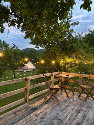 a wooden table and bench next to a fence at Tinutul Luanei Glamping Resort in Bozioru