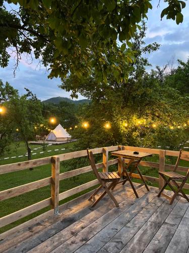 Bozioru的住宿－Tinutul Luanei Glamping Resort，围栏旁的木桌和长凳