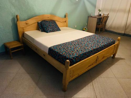 a bed with a wooden frame with a pillow on it at Tea House BNB in Kigali