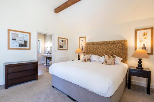 a bedroom with a large white bed and a desk at Bovey Castle in Moretonhampstead