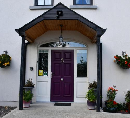 eine lila Vordertür eines Hauses mit Topfpflanzen in der Unterkunft Kilbawn Country House in Kilkenny