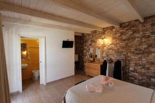 1 dormitorio con cama y pared de piedra en Villa Raggio di Sole parcheggio privato, en Porto Cesareo