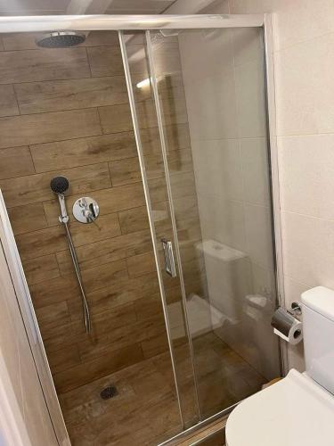 W łazience znajduje się prysznic ze szklanymi drzwiami. w obiekcie OASIS rooms w mieście Karistos