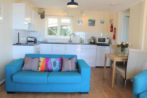 a blue couch in a kitchen with a table at Sandcastles - Mount Brioni in Downderry