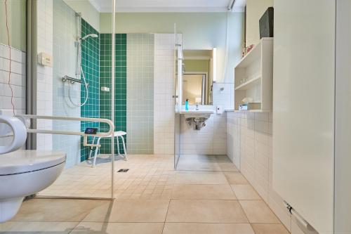a bathroom with a shower and a toilet and a sink at Philippus Inklusionshotel Leipzig in Leipzig